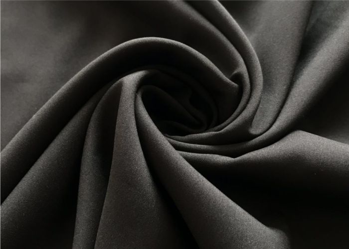 Close-up of black elastane spandex stretch fabric, flexible yarns for sportswear, leggings, activewear, and everyday essentials