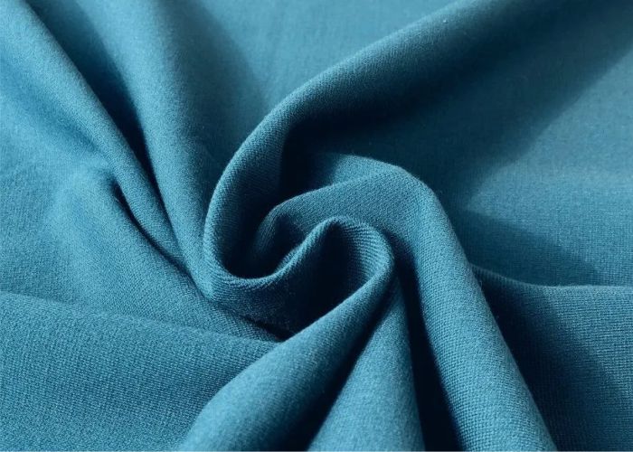 Soft teal viscose rayon blended fabric drape, lightweight breathable material for stylish and comfortable garments