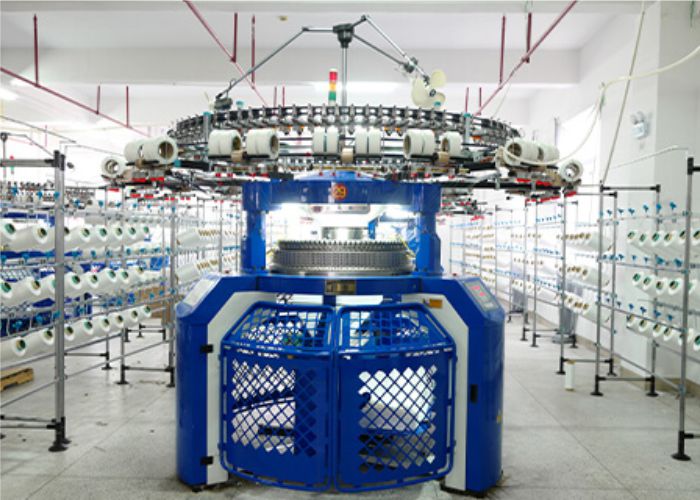 Advanced circular knitting machine producing fabric with auto-stripe, engineered stripe, waffle knit, honeycomb knit, and other specialty structures, uniform GSM and precision quality control in Tirupur